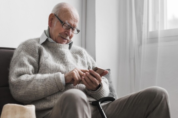 side-view-older-man-nursing-home-using-smartphone